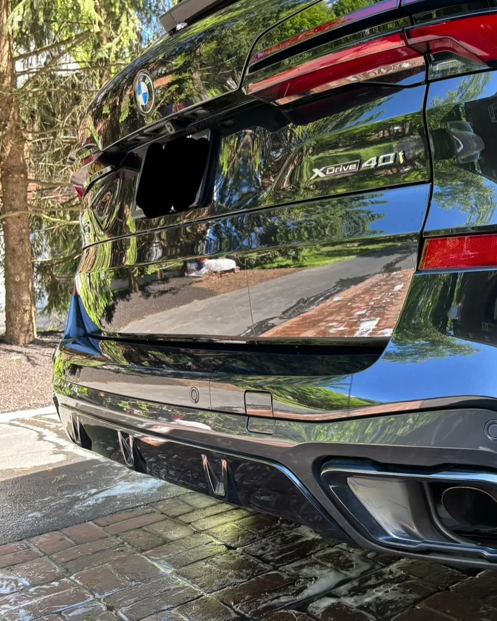 Same BMW X5 rear after washing, glossy mirror-like paint