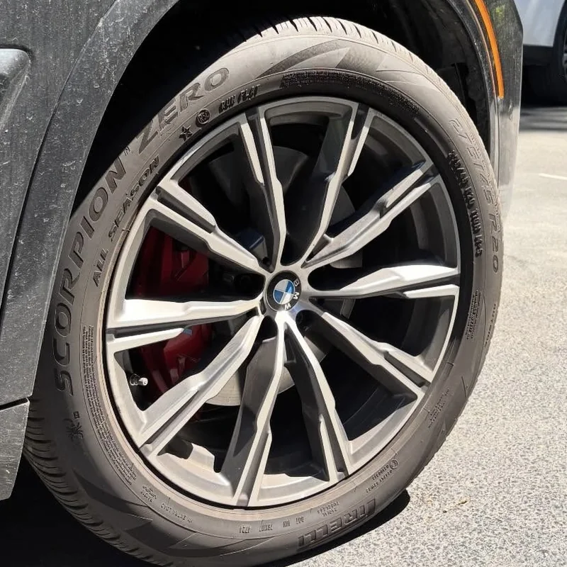 BMW wheel and tire before cleaning, covered in brake dust