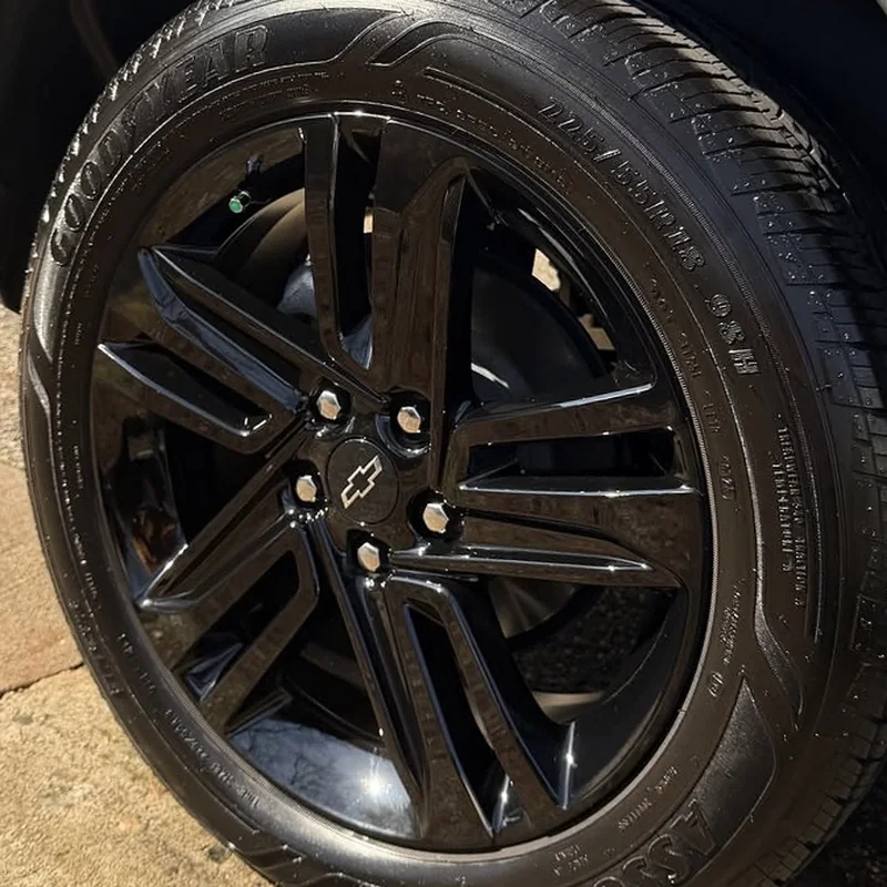 Same Chevy wheel after cleaning, deep gloss black