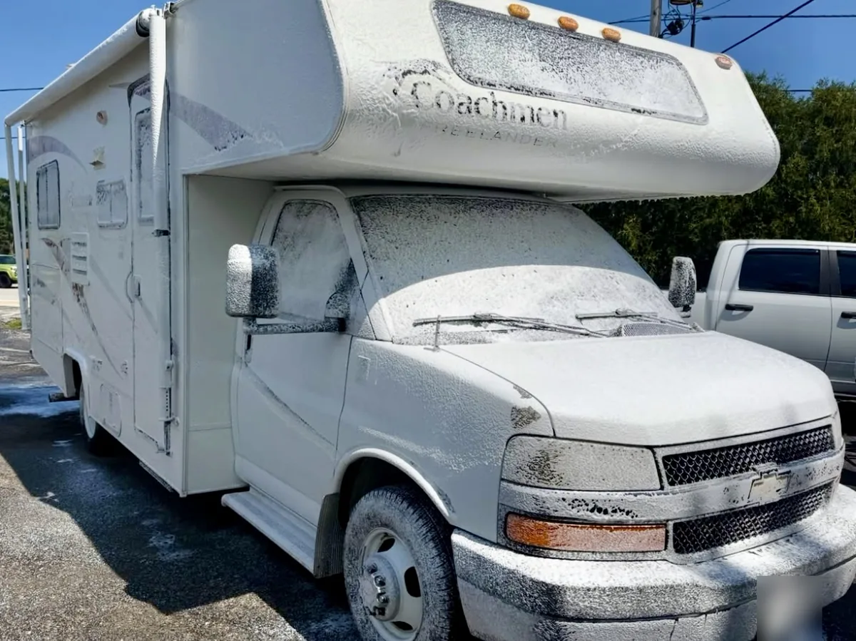 Coachmen Freelander Class C RV covered in foam during a mobile RV wash